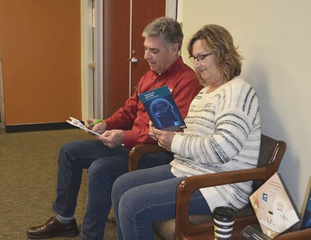 couple sitting and reading hearing material